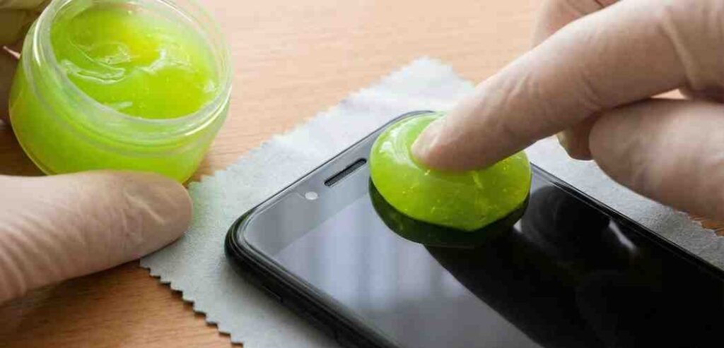  Neon green cleaning cleaning gel being pressed onto the iPhone screen and ear speaker area